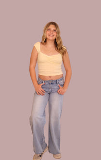 Light-wash wide-leg jeans on model, relaxed fit with front pockets and belt loops